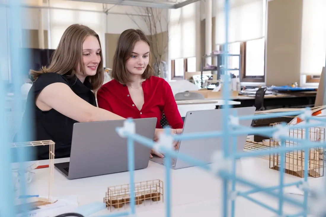 Two students working on an architectural model project.