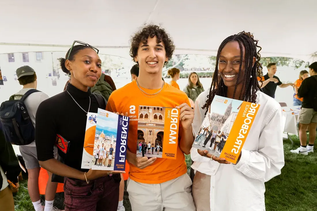 Students holding study abroad brochures.